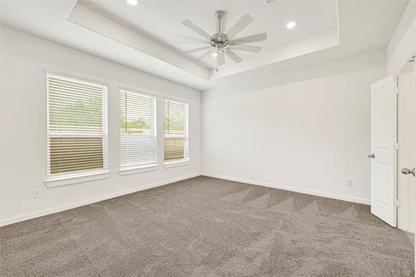 an empty room with a ceiling fan and window