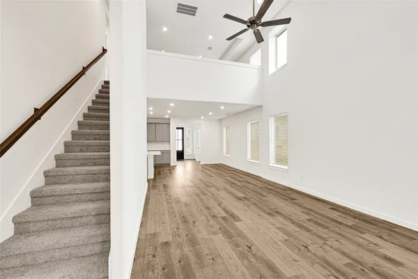 a view of a hallway with wooden floor and staircase