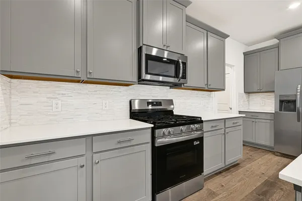 a kitchen with granite countertop white cabinets stainless steel appliances and a sink
