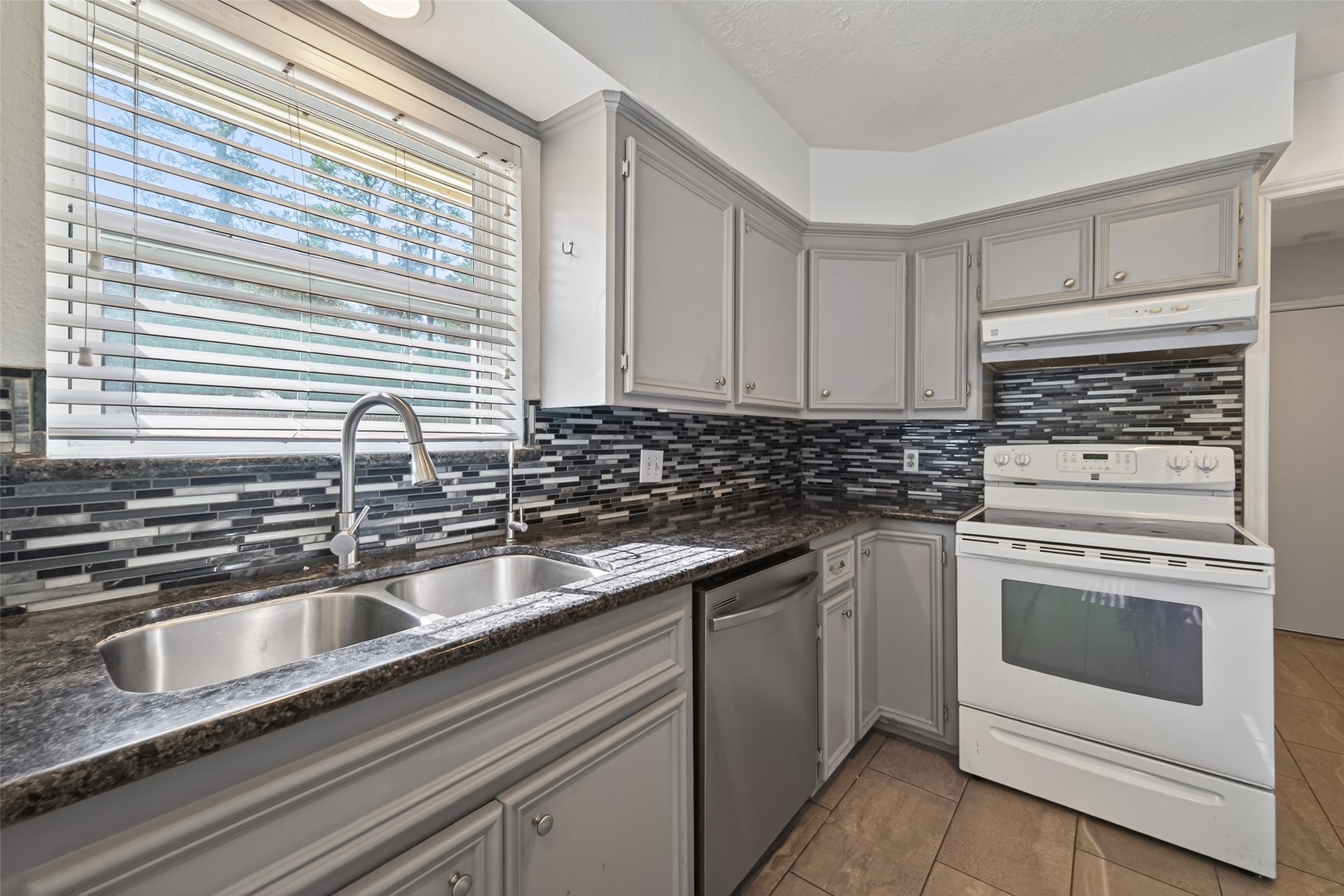 11811 Beverly Drive Houston, TX 77065 - Photo 15 of 48 a kitchen with granite countertop white cabinets and white appliances
