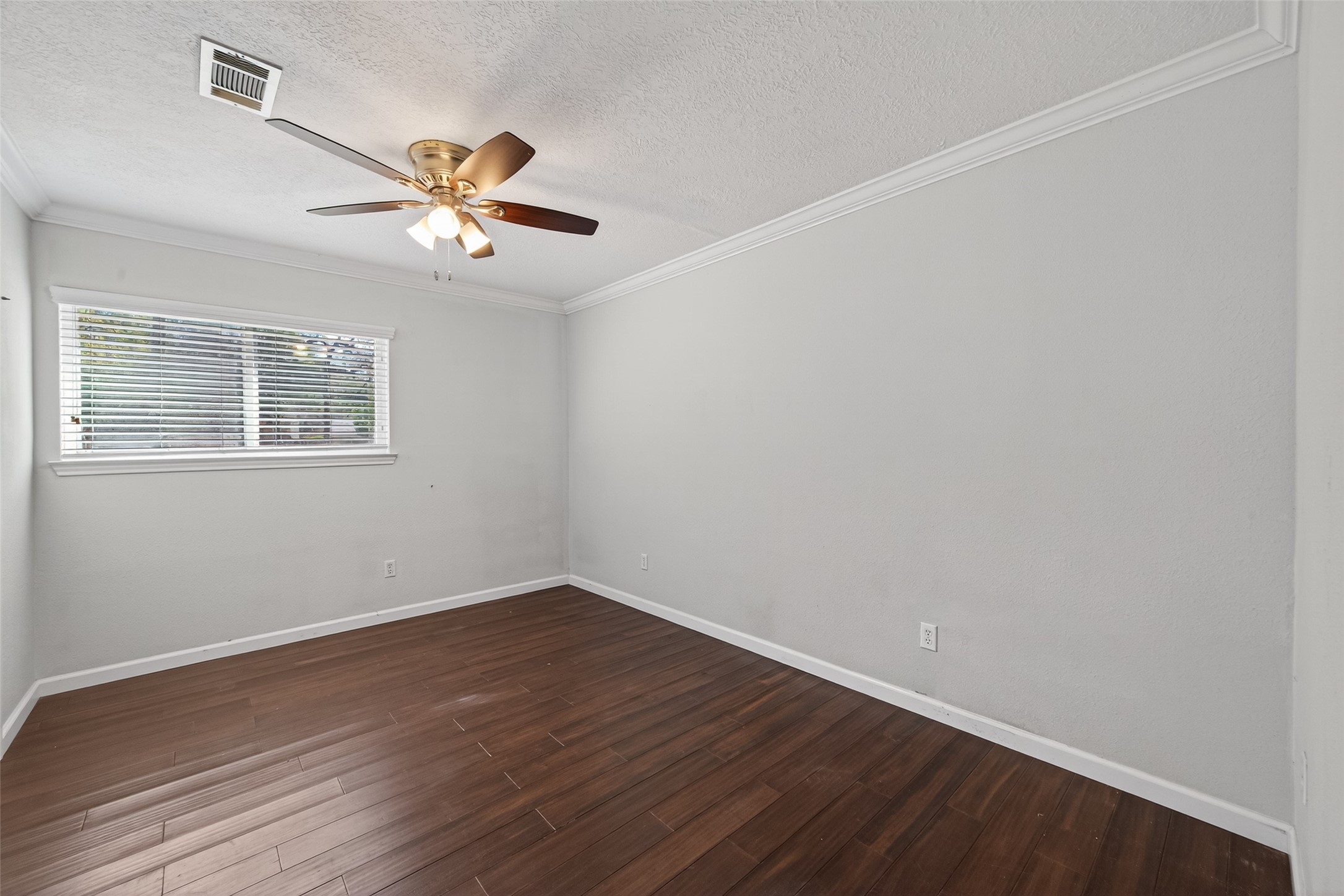 11811 Beverly Drive Houston, TX 77065 - Photo 27 of 48 a view of an empty room with wooden floor and a ceiling fan