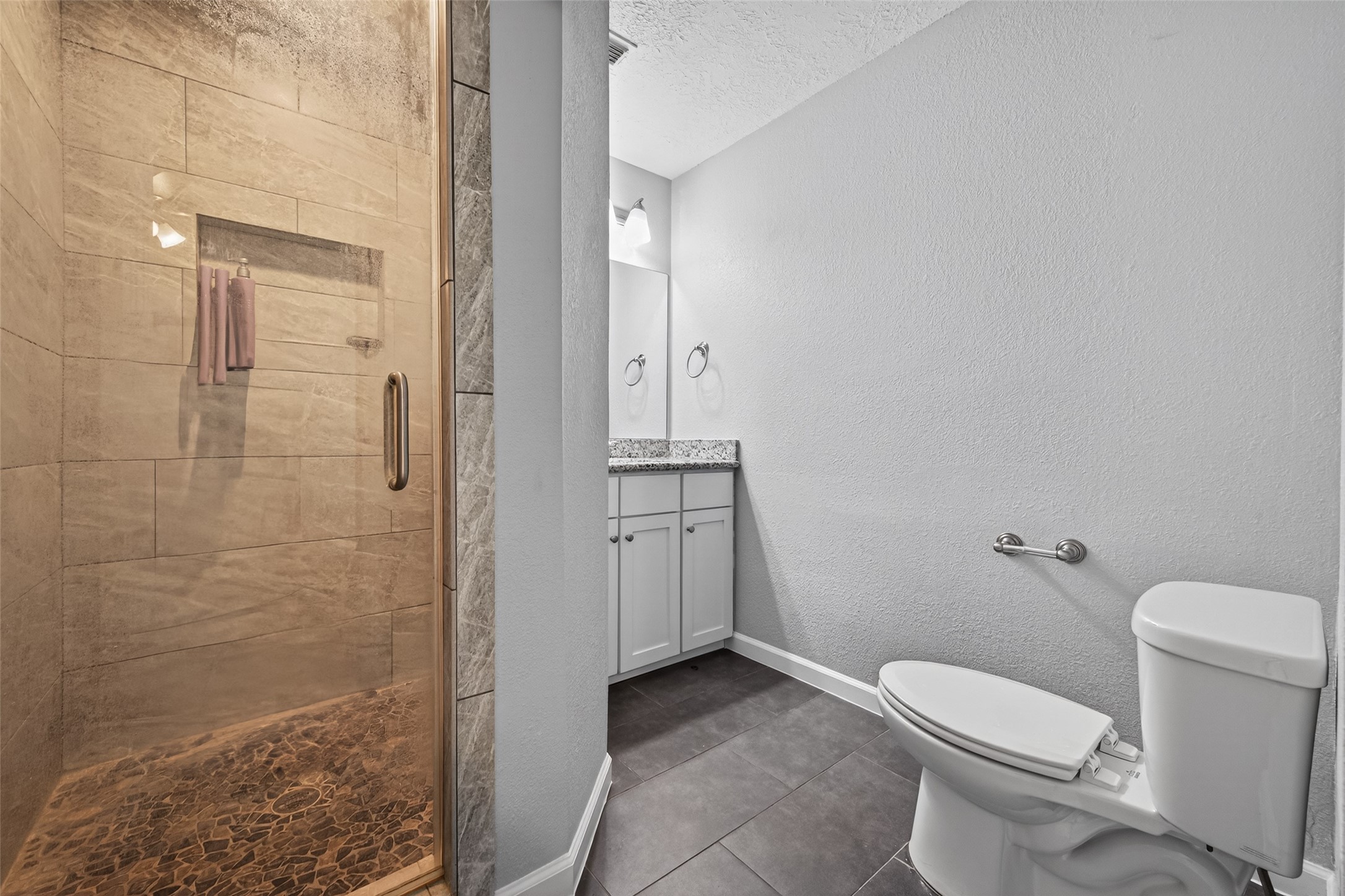 11811 Beverly Drive Houston, TX 77065 - Photo 31 of 48 a bathroom with a granite countertop toilet a sink and shower