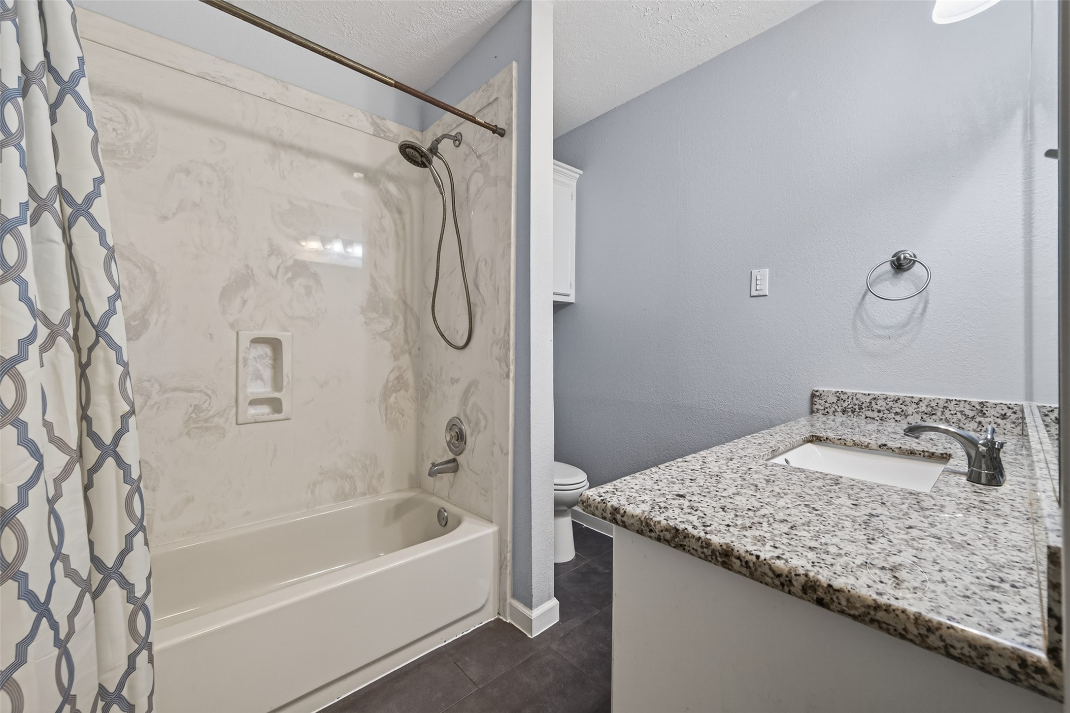 11811 Beverly Drive Houston, TX 77065 - Photo 33 of 48 a bathroom with a granite countertop sink a bathtub and shower