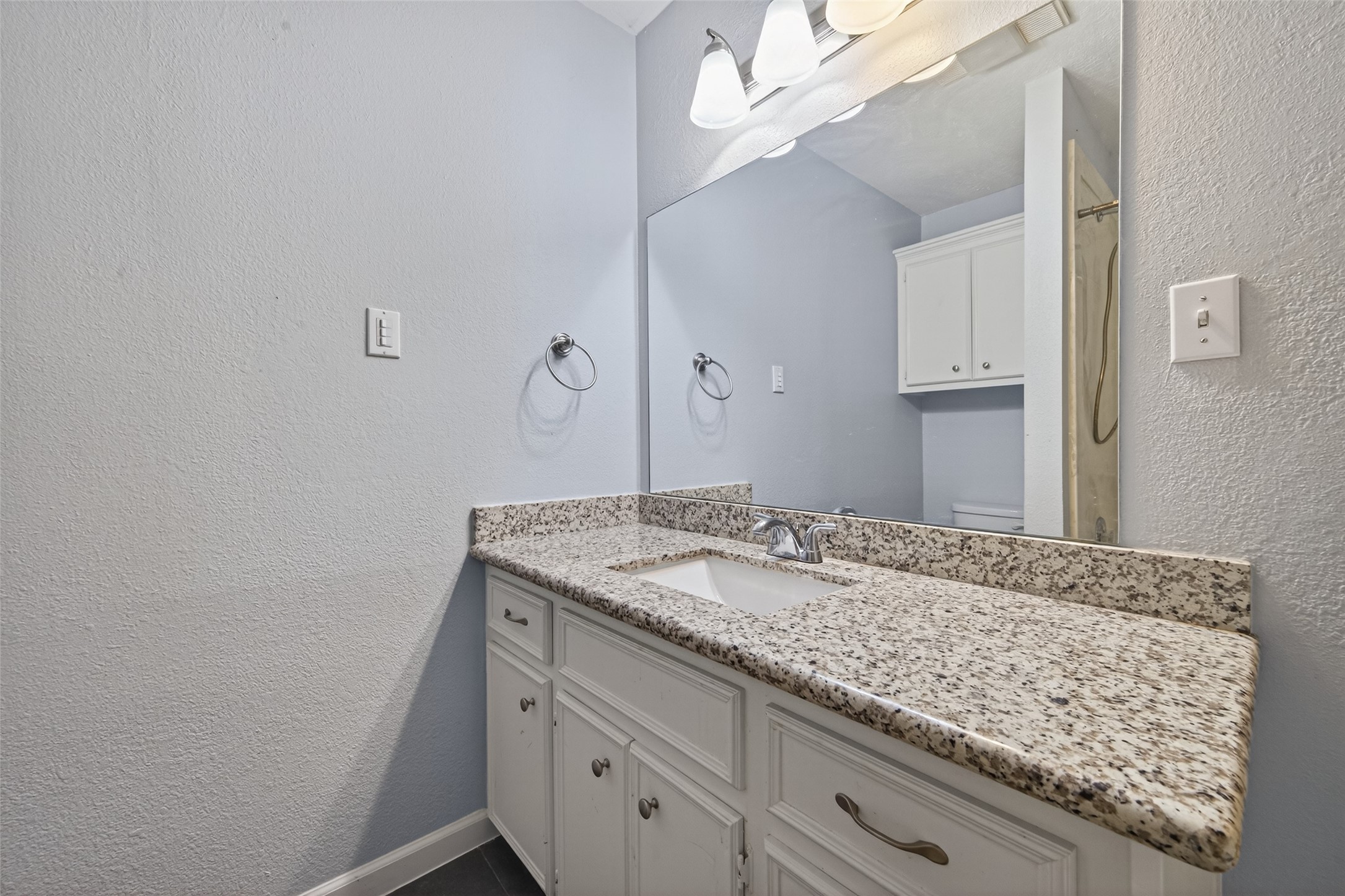 11811 Beverly Drive Houston, TX 77065 - Photo 34 of 48 a bathroom with a granite countertop sink and a mirror