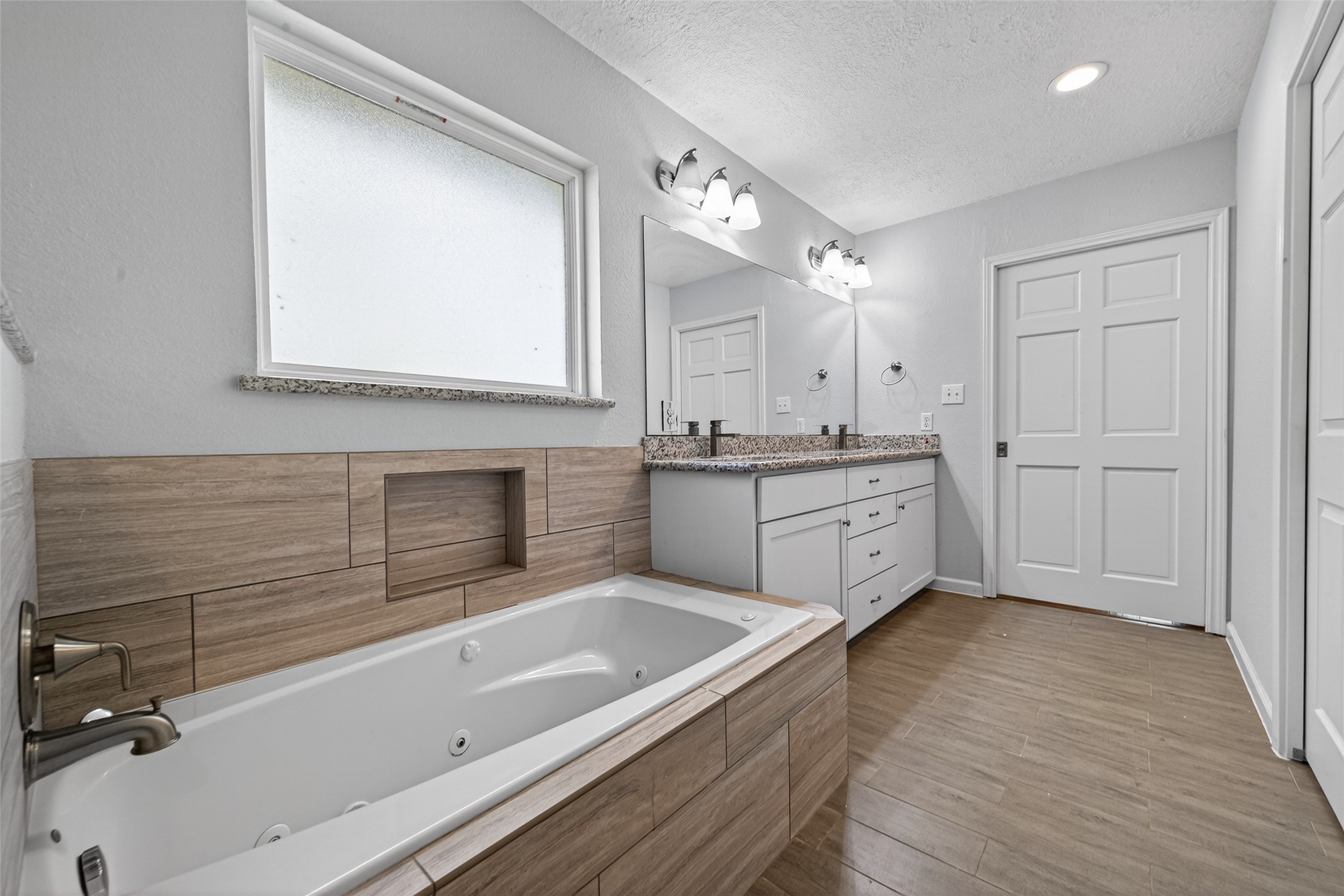 11811 Beverly Drive Houston, TX 77065 - Photo 43 of 48 a spacious bathroom with a granite countertop sink mirror and bathtub