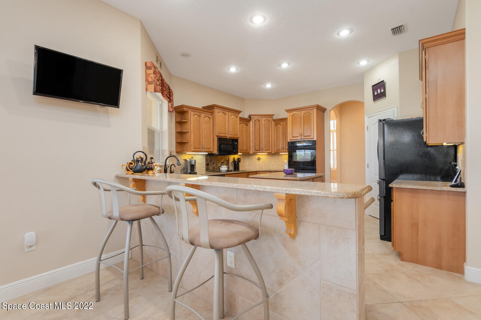 4270 Stoney Point Road Melbourne, FL 32940 - Photo 7 of 68 a kitchen with stainless steel appliances kitchen island granite countertop a sink and a stove top oven with wooden floor