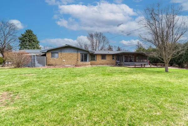 a view of a house with a big yard and large tree