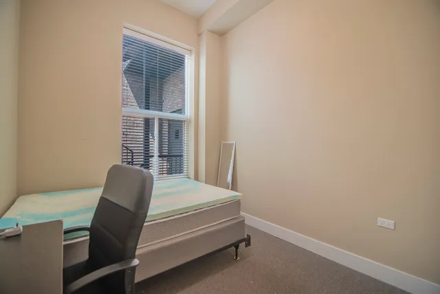 a bedroom with a chair and a window