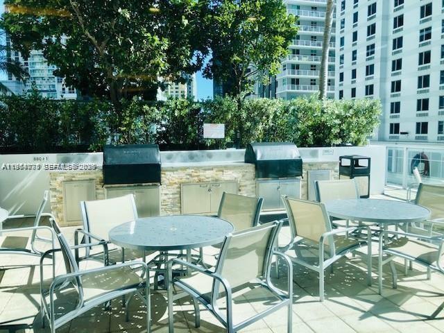 79 Southwest 12th Street, Unit 2402S Miami, FL 33130 - Photo 22 of 23 a view of a patio with table and chairs and potted plants