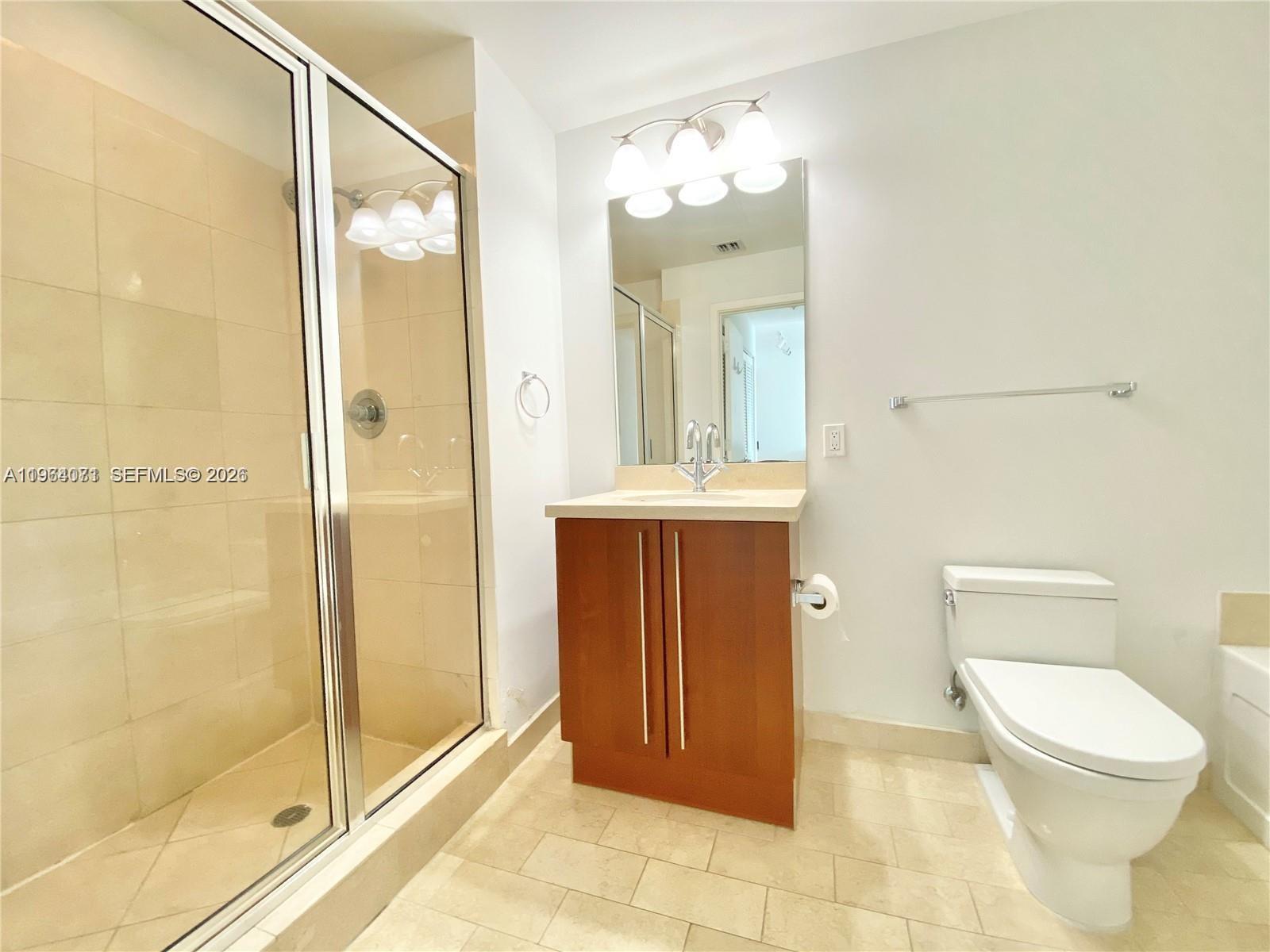 79 Southwest 12th Street, Unit 2402S Miami, FL 33130 - Photo 9 of 23 a bathroom with a toilet a sink and shower