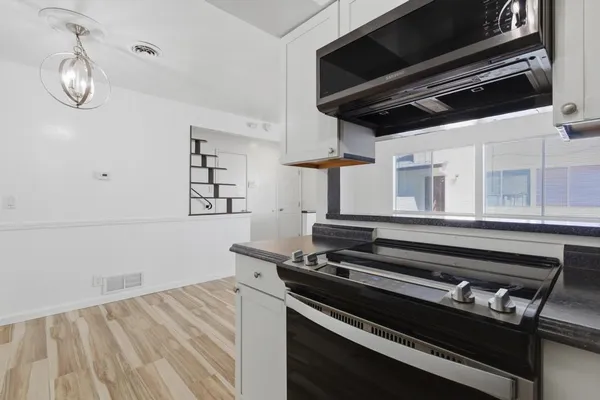a kitchen with stainless steel appliances granite countertop a stove top oven a refrigerator and a sink