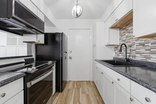 a stove top oven sitting inside of a kitchen
