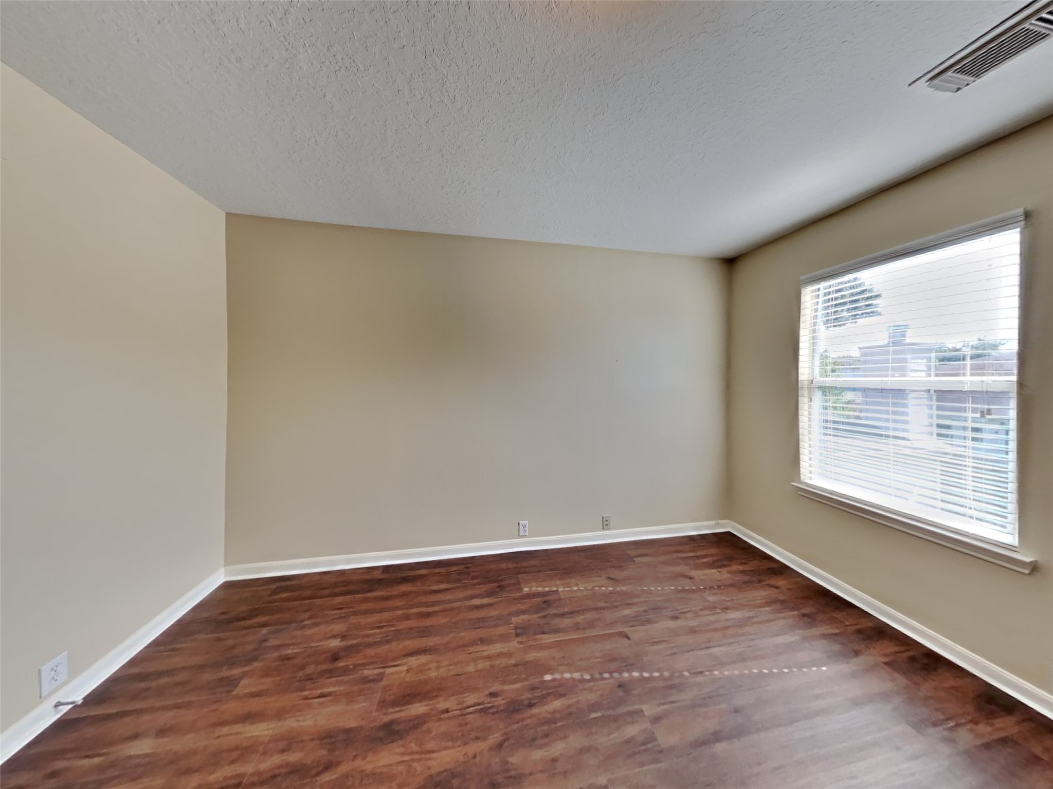 18322 Valiant Brook Court Humble, TX 77346 - Photo 13 of 20 a view of an empty room with wooden floor and a window