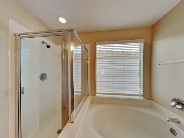 a bathroom with a tub shower and a sink