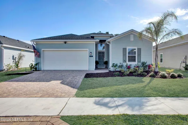 a front view of a house with a garden and plants