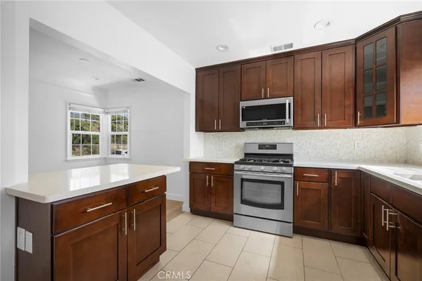 a kitchen with stainless steel appliances granite countertop wooden cabinets a stove top oven a sink and dishwasher
