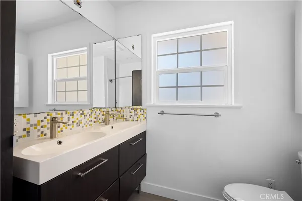 a bathroom with a sink vanity mirror and toilet