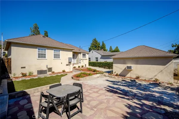 a view of a patio with table and chairs under an umbrella