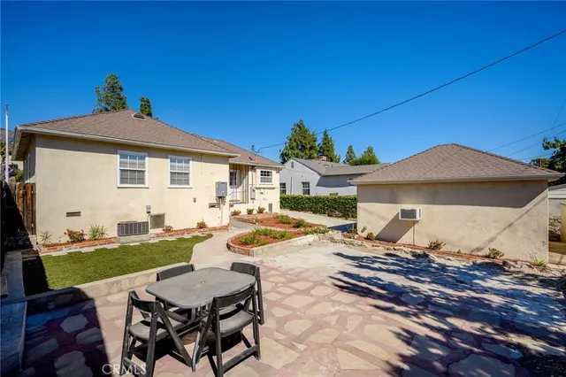 a view of a patio with table and chairs under an umbrella
