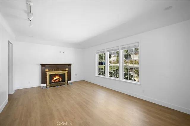 an empty room with a fireplace and windows