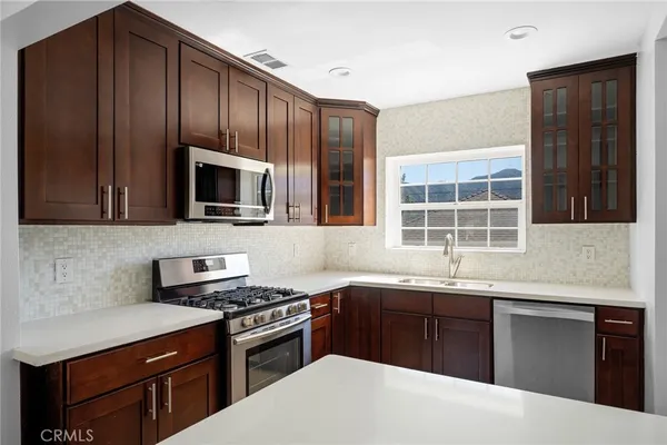 a kitchen with granite countertop wooden cabinets and stainless steel appliances