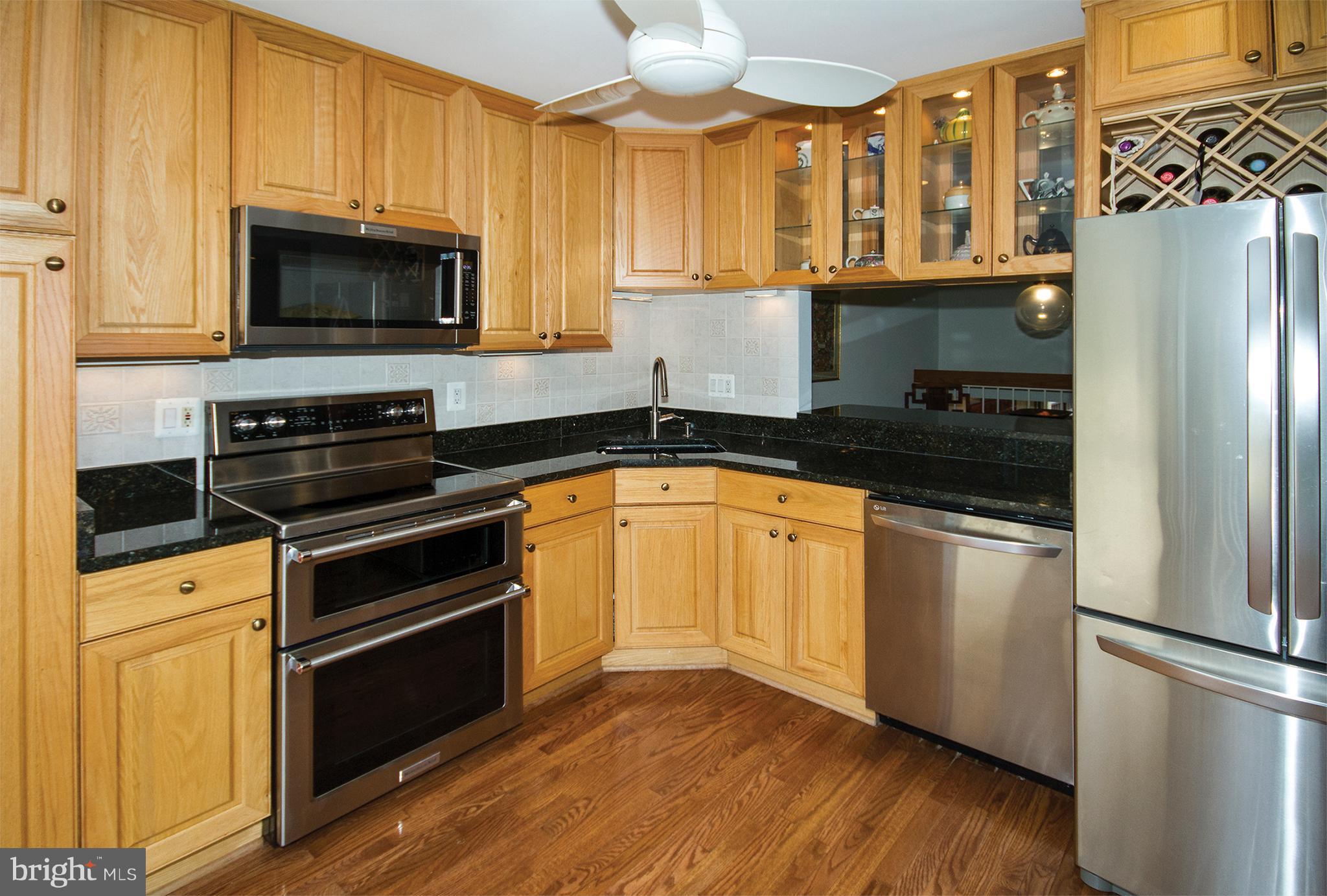 11116 Saffold Way Reston, VA 20190 - Photo 3 of 30 a kitchen with granite countertop a refrigerator stove and microwave