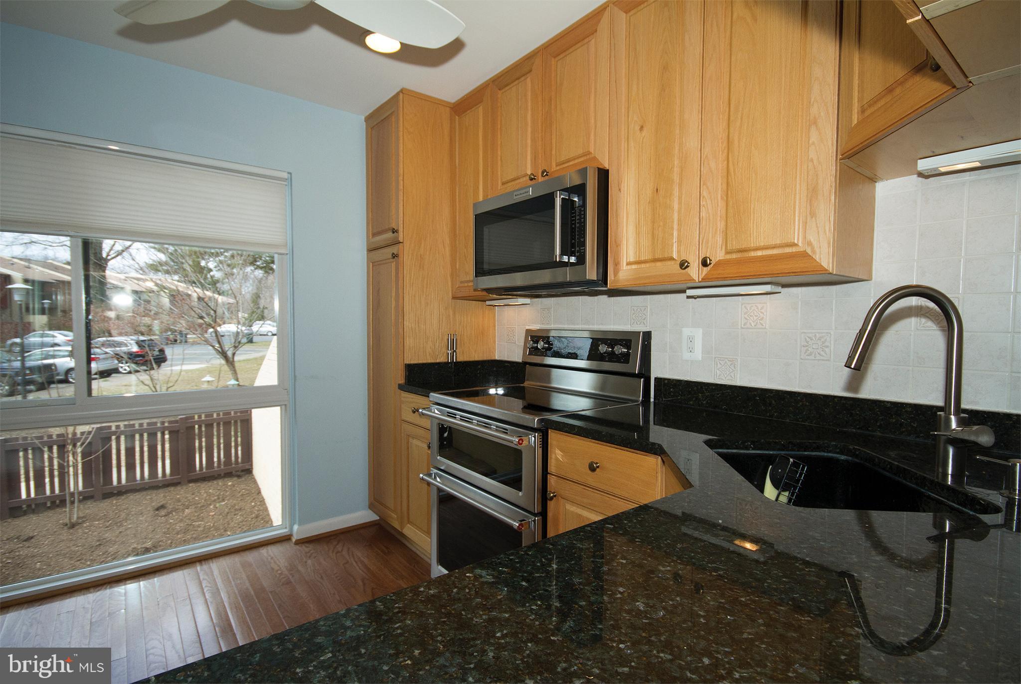 11116 Saffold Way Reston, VA 20190 - Photo 5 of 30 a kitchen with stainless steel appliances granite countertop a stove a sink and a microwave