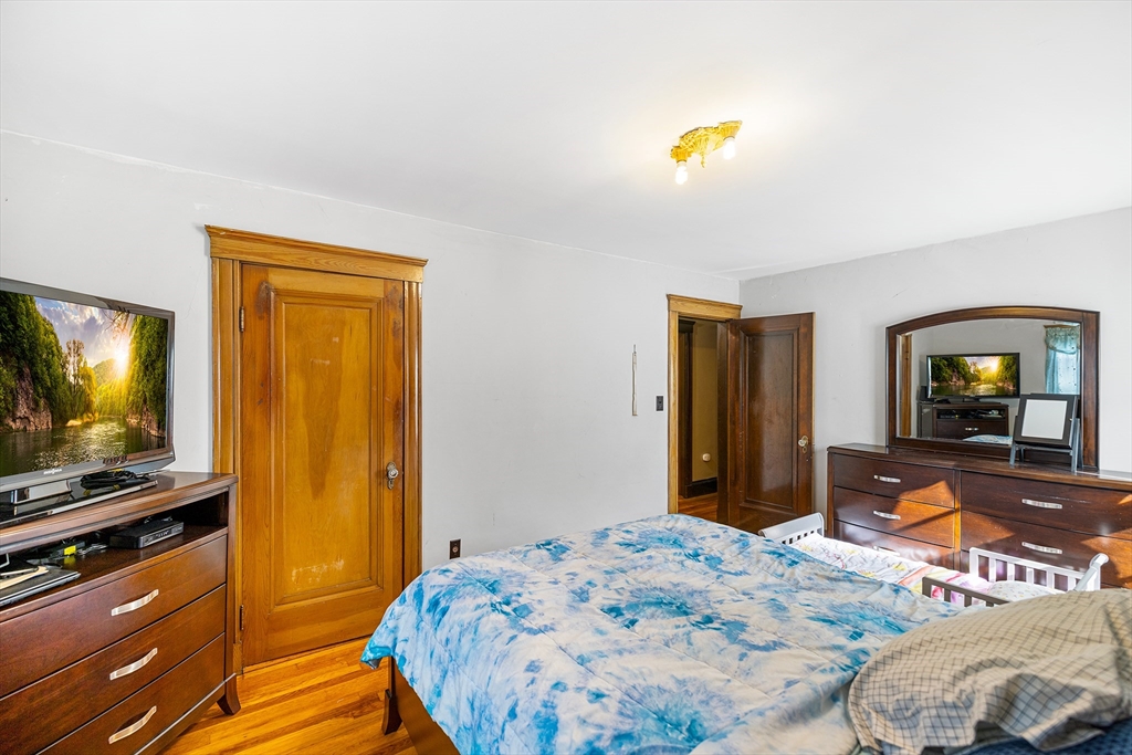 11 Linwood Road Lynn, MA 01905 - Photo 18 of 25 a bedroom with a bed and wooden floor