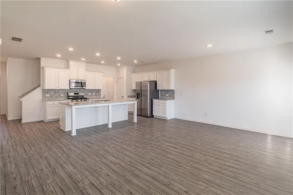 a large kitchen with stainless steel appliances granite countertop a stove and a refrigerator