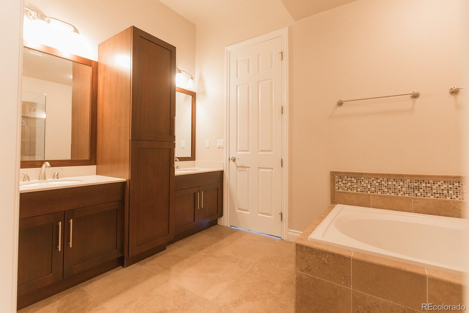 1120 Delaware Street, Unit 311 Denver, CO 80204 - Photo 14 of 25 a bathroom with a tub sink and mirror