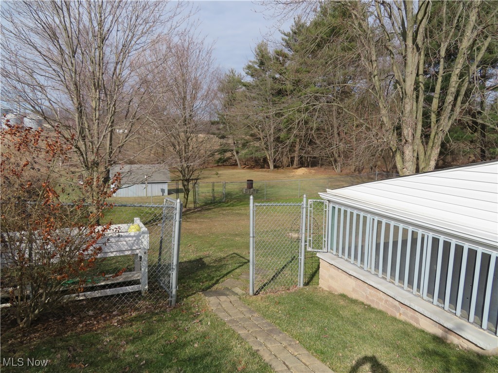 View of yard featuring fence and a gate