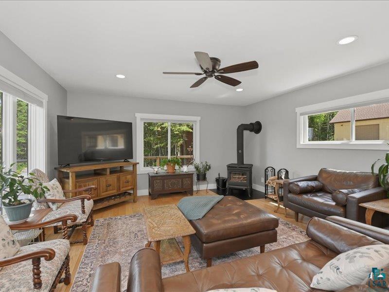 88440 Huron Street Cornucopia, WI 54827 - Photo 11 of 44 Living area featuring wood-finish flooring, a ceiling fan with integrated lighting, and recessed overhead lighting. A new wood stove (Pacific Energy) for those cozy nights.