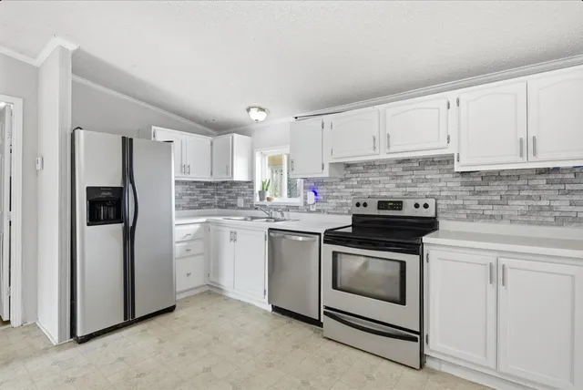 a kitchen with granite countertop white cabinets and white appliances