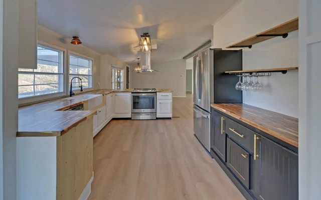 a large kitchen with a large window and stainless steel appliances