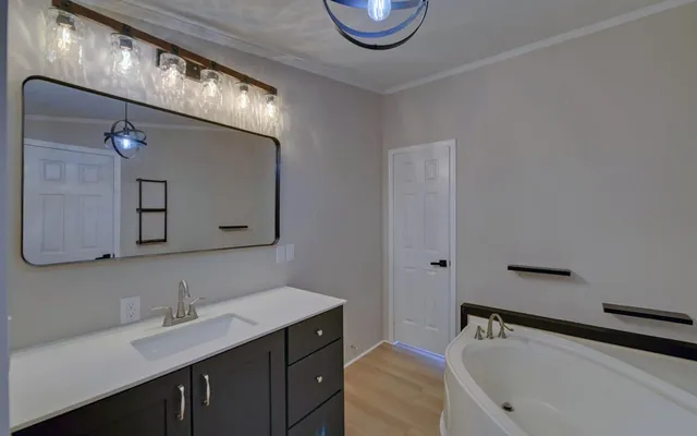 a bathroom with a tub sink and mirror