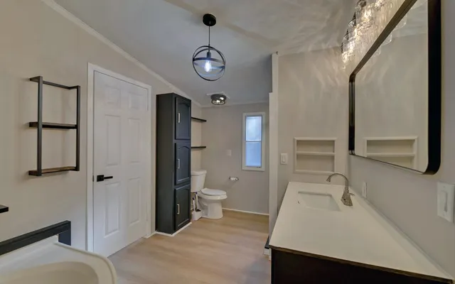 a bathroom with a sink a toilet and shower