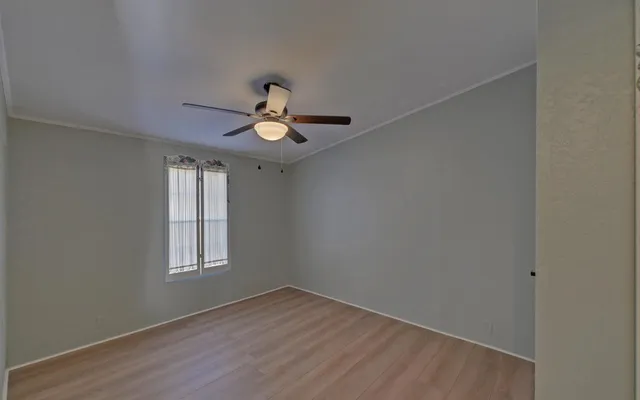 an empty room with window and wooden floor