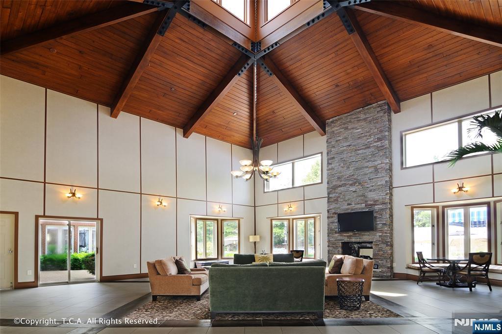 202 Jefferson Court, Unit 202 Edgewater, NJ 07020 - Photo 2 of 6 a living room with a couch a dining table and chairs