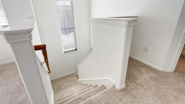 an empty room with chandelier fan and windows