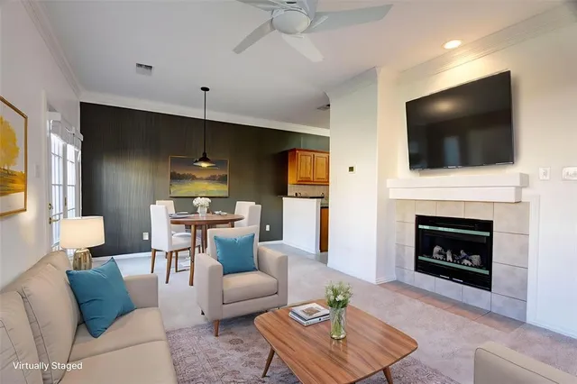 a living room with furniture a flat screen tv and a fireplace