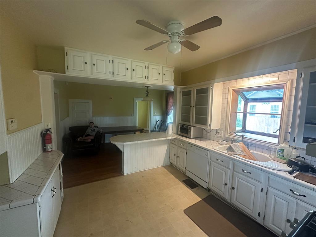 504 1st Street Terrell, TX 75160 - Photo 4 of 27 Kitchen featuring white cabinetry, tile countertops, and a ceiling fan