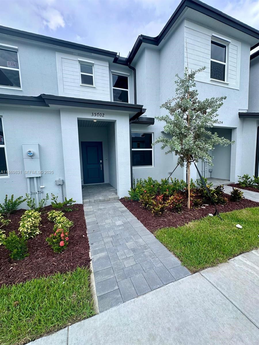 35702 Southwest 178th Court, Unit 35702 Homestead, FL 33034 - Photo 1 of 38 a front view of a house with garden