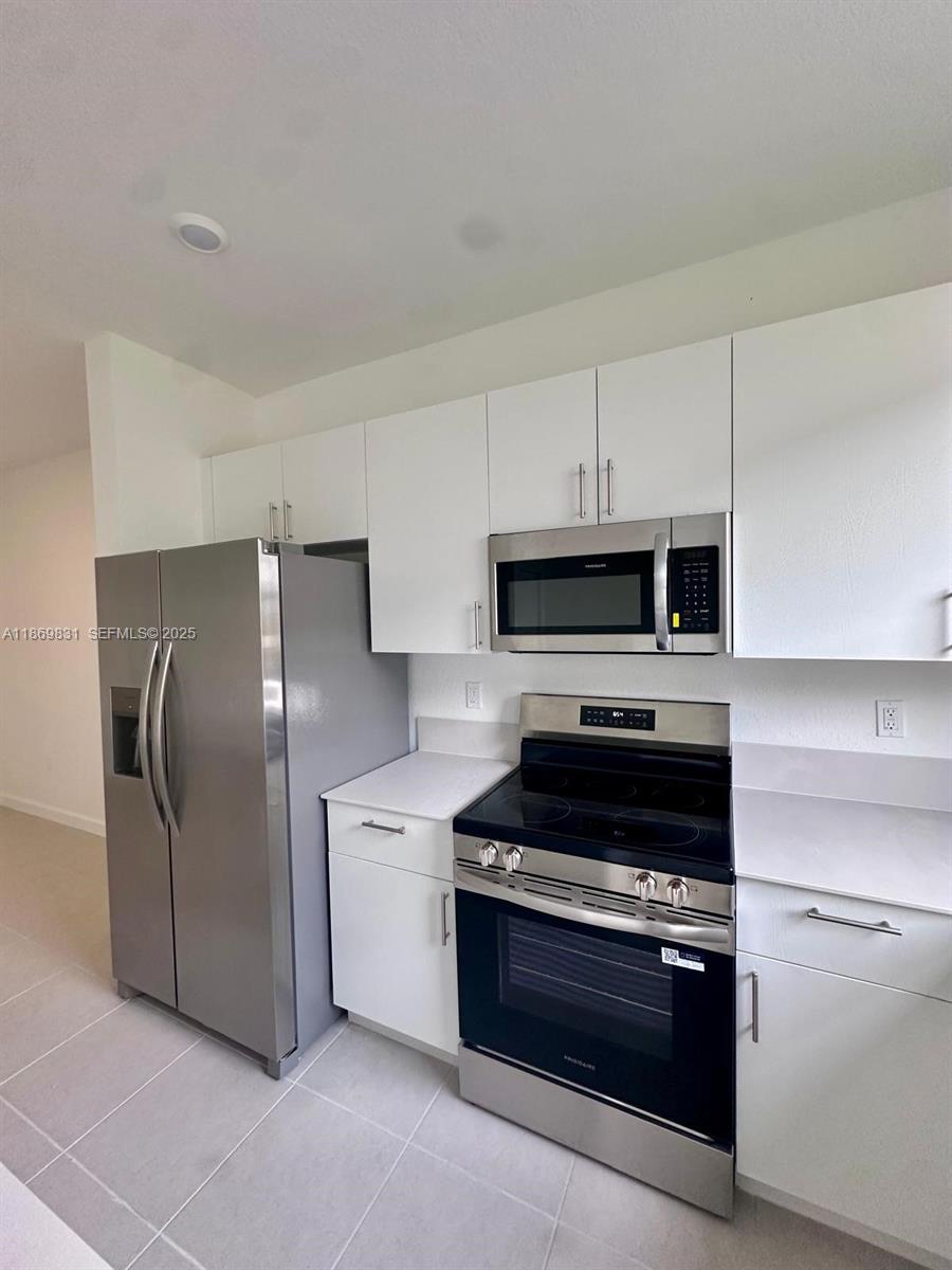 35702 Southwest 178th Court, Unit 35702 Homestead, FL 33034 - Photo 20 of 38 a kitchen with stainless steel appliances kitchen island granite countertop a refrigerator stove and sink