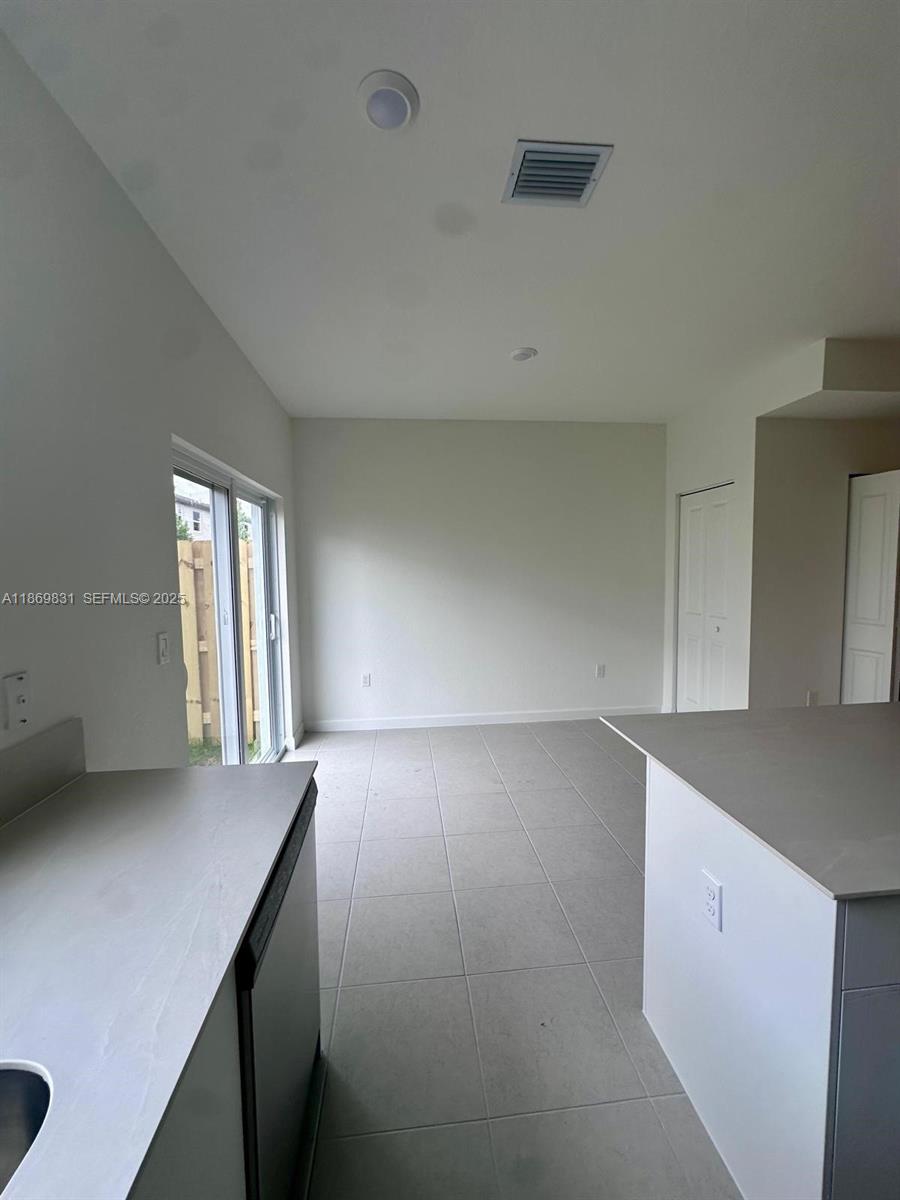 35702 Southwest 178th Court, Unit 35702 Homestead, FL 33034 - Photo 22 of 38 a view of an empty room with window and wooden floor