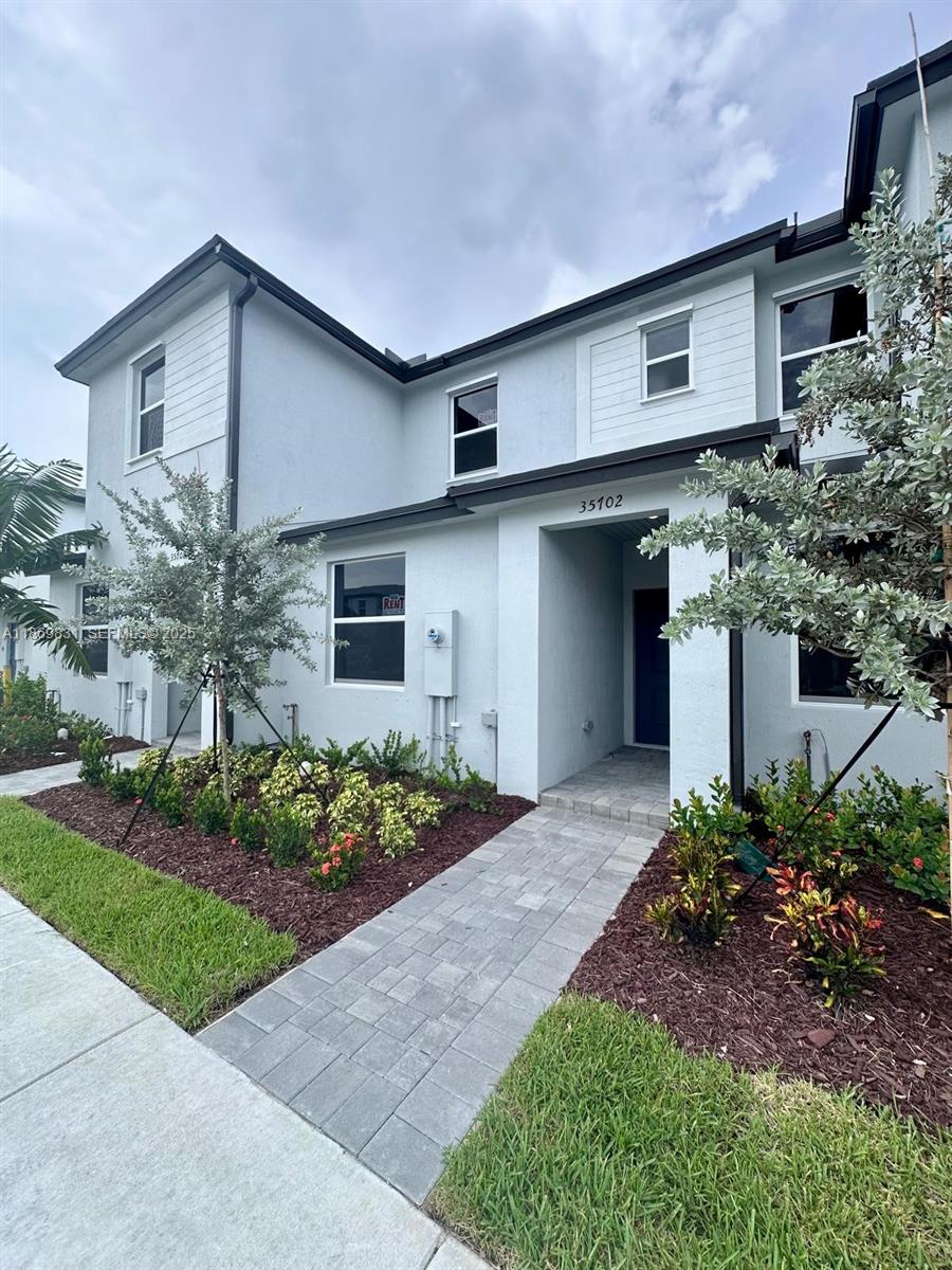 35702 Southwest 178th Court, Unit 35702 Homestead, FL 33034 - Photo 4 of 38 a front view of a house with garden