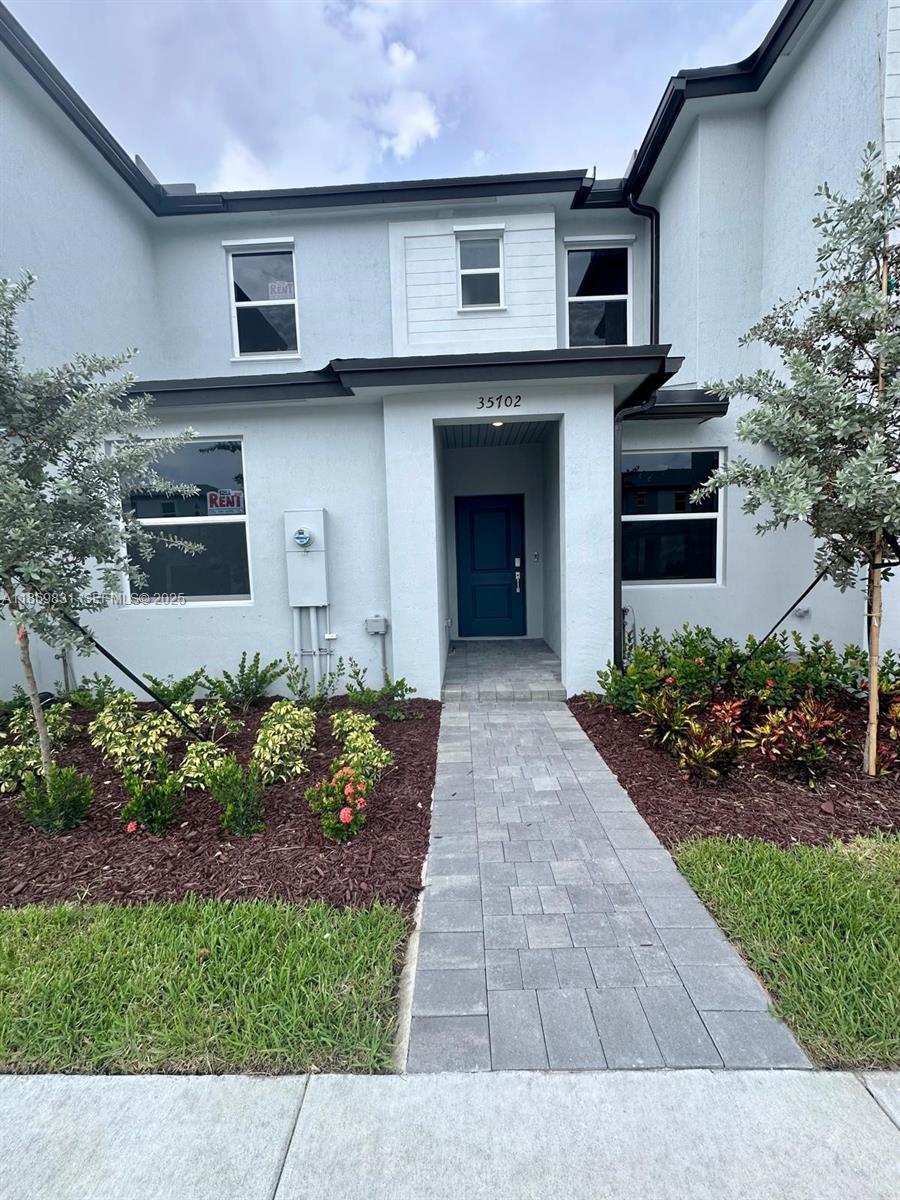 35702 Southwest 178th Court, Unit 35702 Homestead, FL 33034 - Photo 5 of 38 a front view of a house with a garden