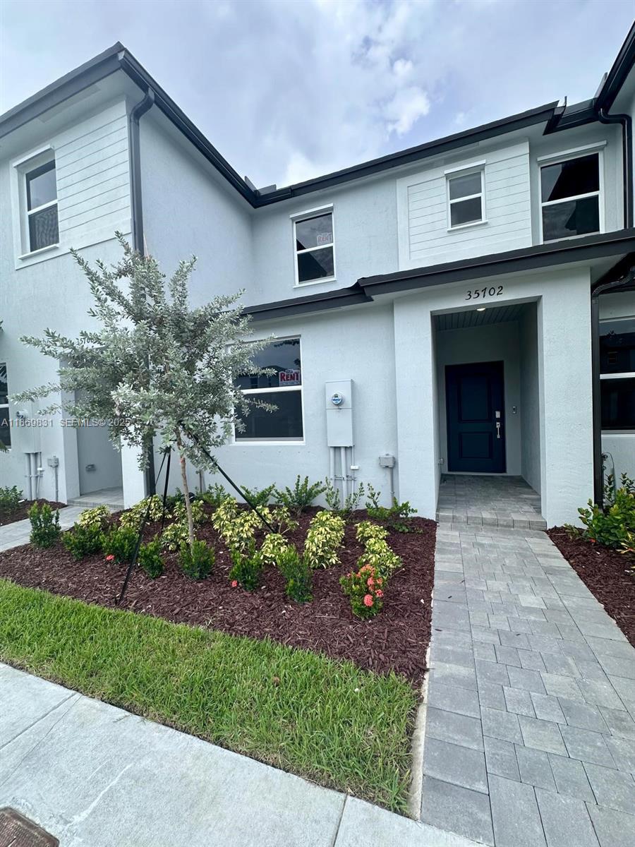 35702 Southwest 178th Court, Unit 35702 Homestead, FL 33034 - Photo 6 of 38 a front view of a house with a garden