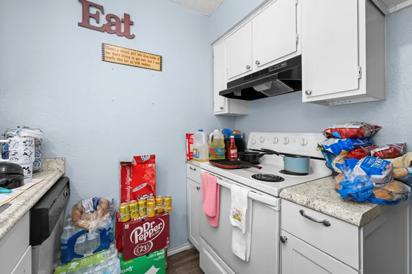 a utility room with lots of clutter and cabinets