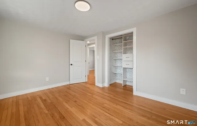 a view of empty room with wooden floor
