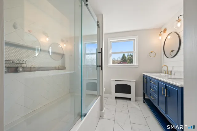 a spacious bathroom with a double vanity sink a mirror and a shower